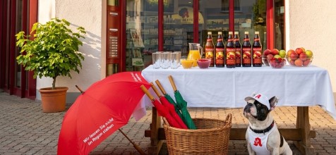 Ein Stisch mit Säften und Gläsern mit Apotheken Hund Leopold vor der Linden-Apotheke