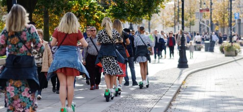 E-Scooterahrer auf Bürgersteig mit Fußgängern