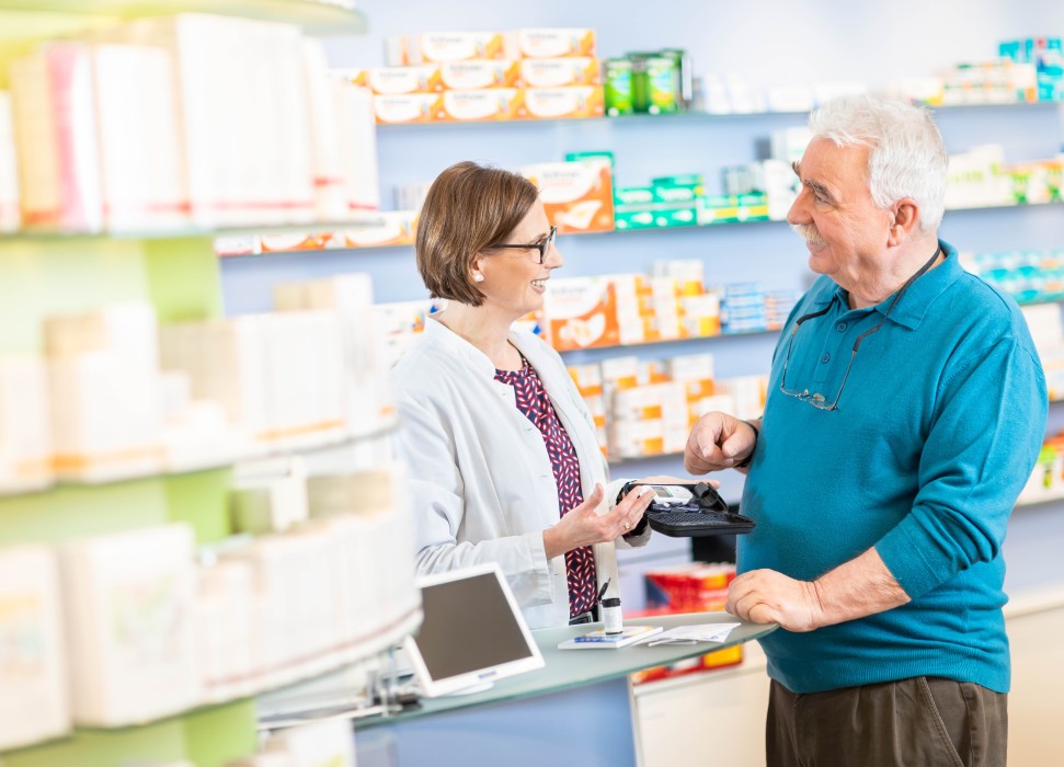 Apothekenmitarbeiterin bei der Beratung eines Kunden in der Apotheke
