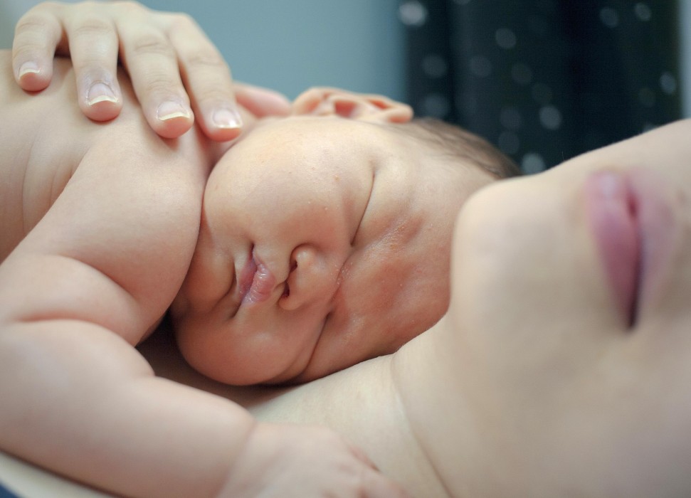 Baby liegt in den Armen der Mutter