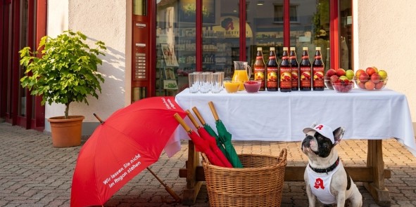 Ein Stisch mit Säften und Gläsern mit Apotheken Hund Leopold vor der Linden-Apotheke