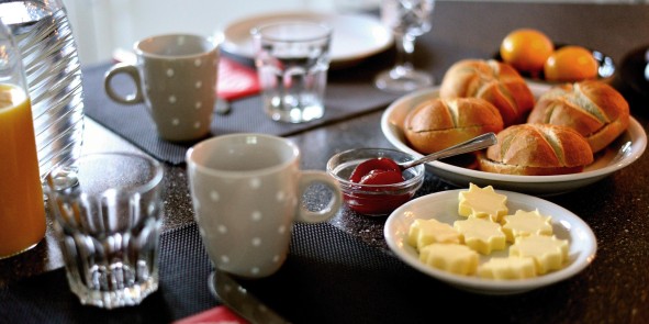 Frühstückstisch mit Brötchen, Butter und Getränken