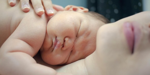 Baby liegt in den Armen der Mutter